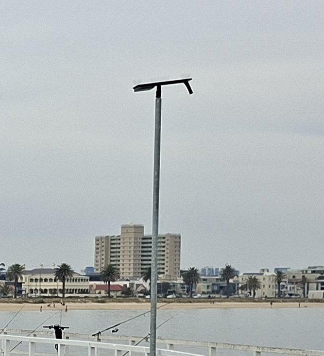 The pier photo with a lamp post standing in front of the beachfront