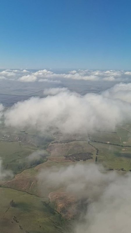A frame from the clip: cloud over farmland, seen from a plane window on the descent