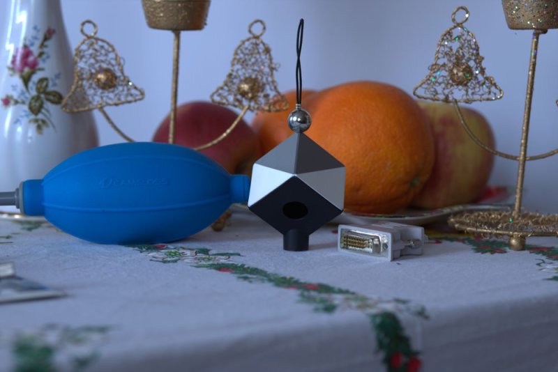 The converted JPG: a table with fruit, a blue air blower, a grey reference card and a cable